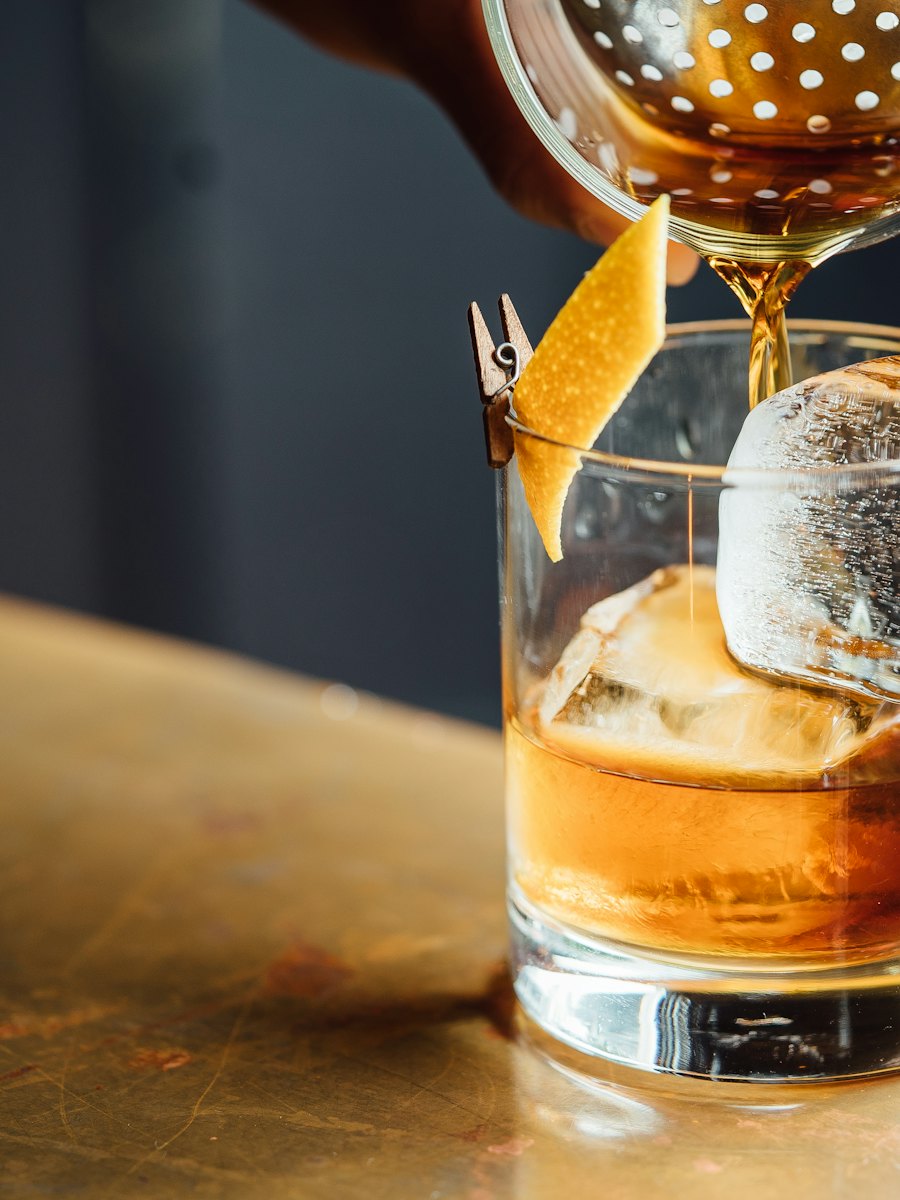 Whisky sendo servido em copo baixo com gelo
