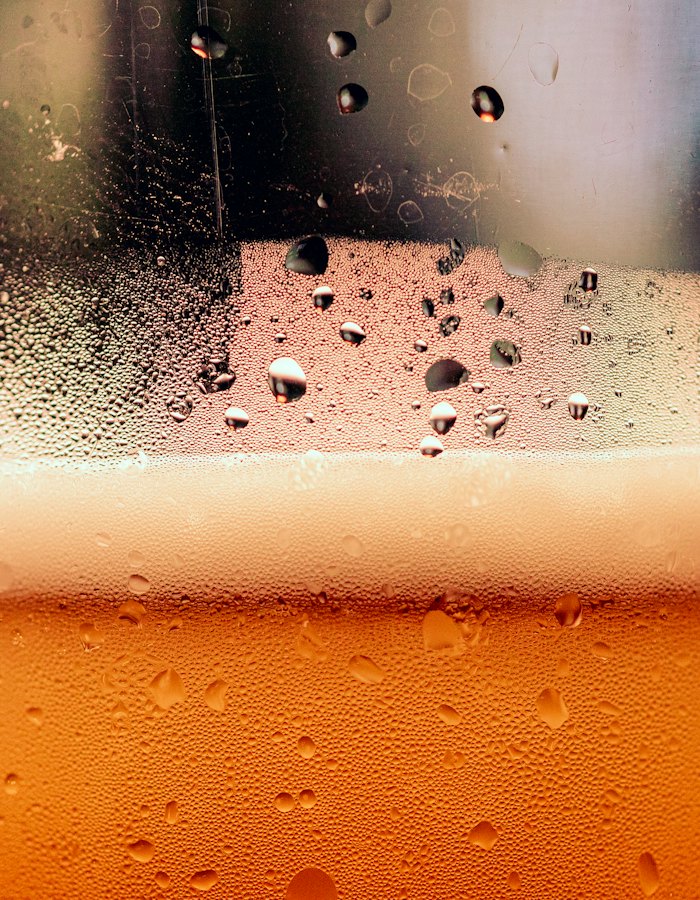 Cerveja dourada com bolhas e colarinho